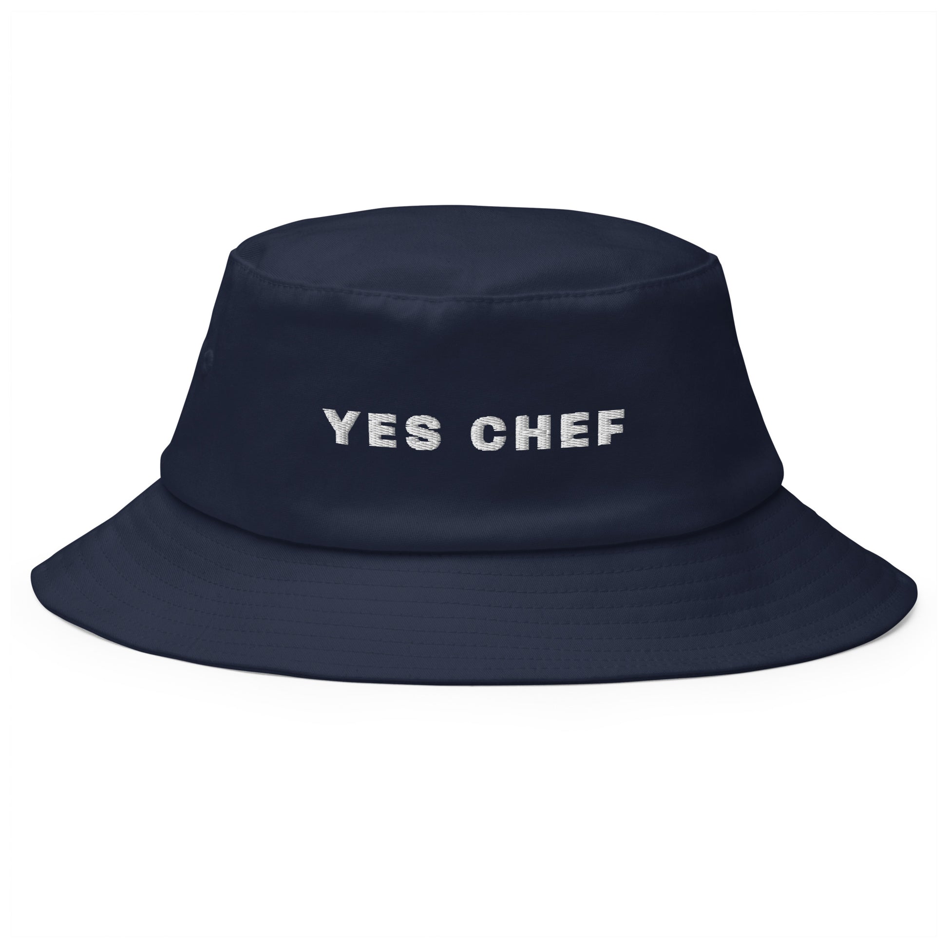 Produktfoto des bestickten Fischerhuts 'I YES CHEF' von YourCapGuy auf einem weißen Hintergrund. Der Hut ist in einem stilvollen Farbton gehalten, der aussagekräftige Schriftzug setzt einen humorvollen Akzent.