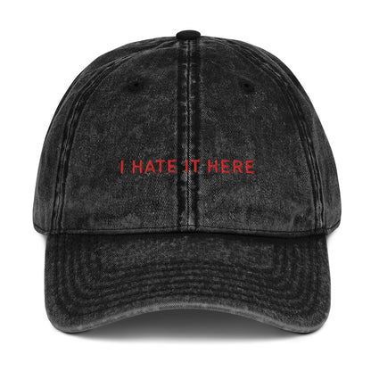 Produktbild einer Vintage-Cap mit dem Spruch 'I HATE IT HERE' auf einem weißen Hintergrund. Das perfekte Accessoire für Partymuffel.
