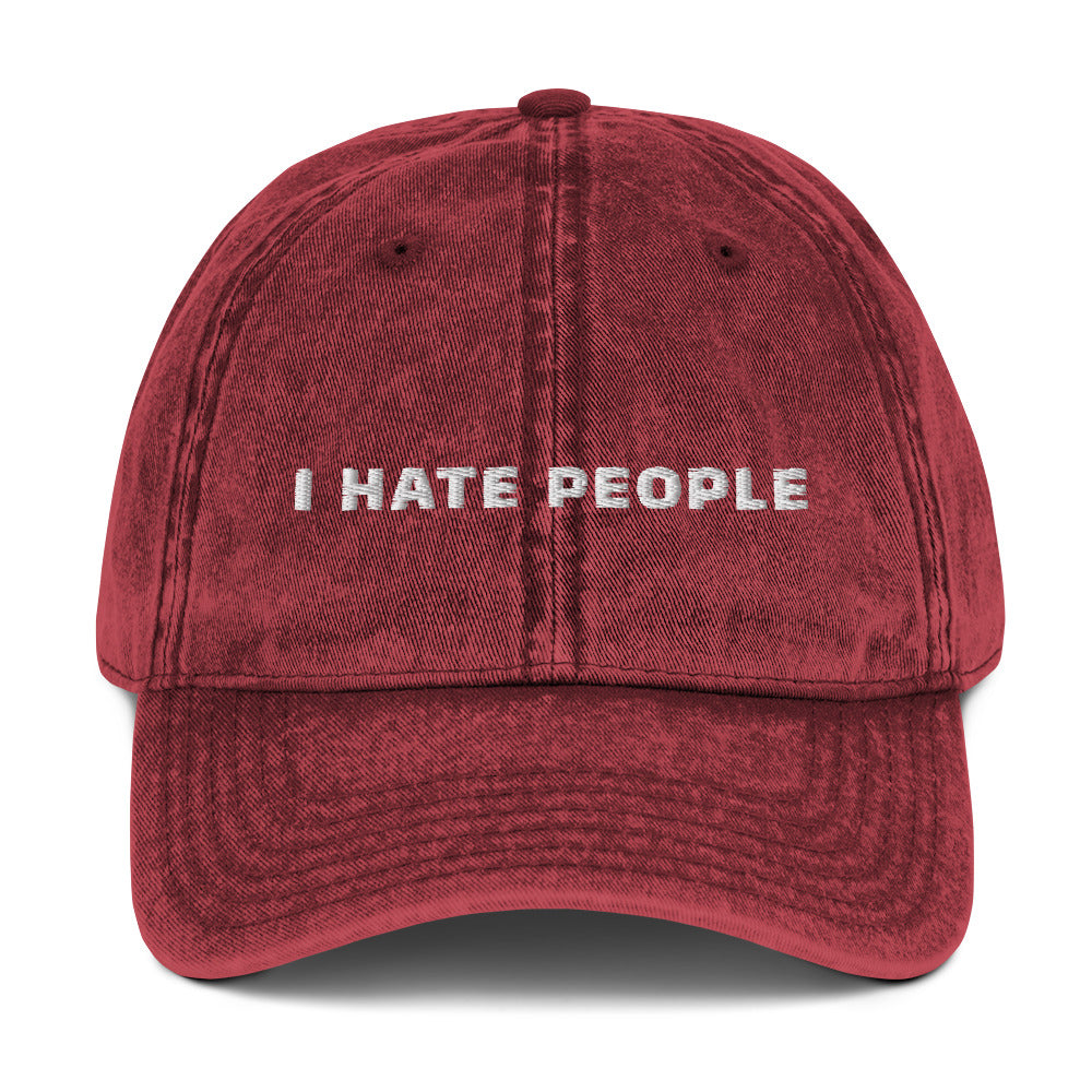 Produktbild der bestickten Vintage-Cap 'I HATE PEOPLE' von YourCapGuy auf einem weißen Hintergrund. Die Cap ist in einem schicken Vintage-Stil gehalten, der Schriftzug stellt einen humorvollen Kontrast dar.