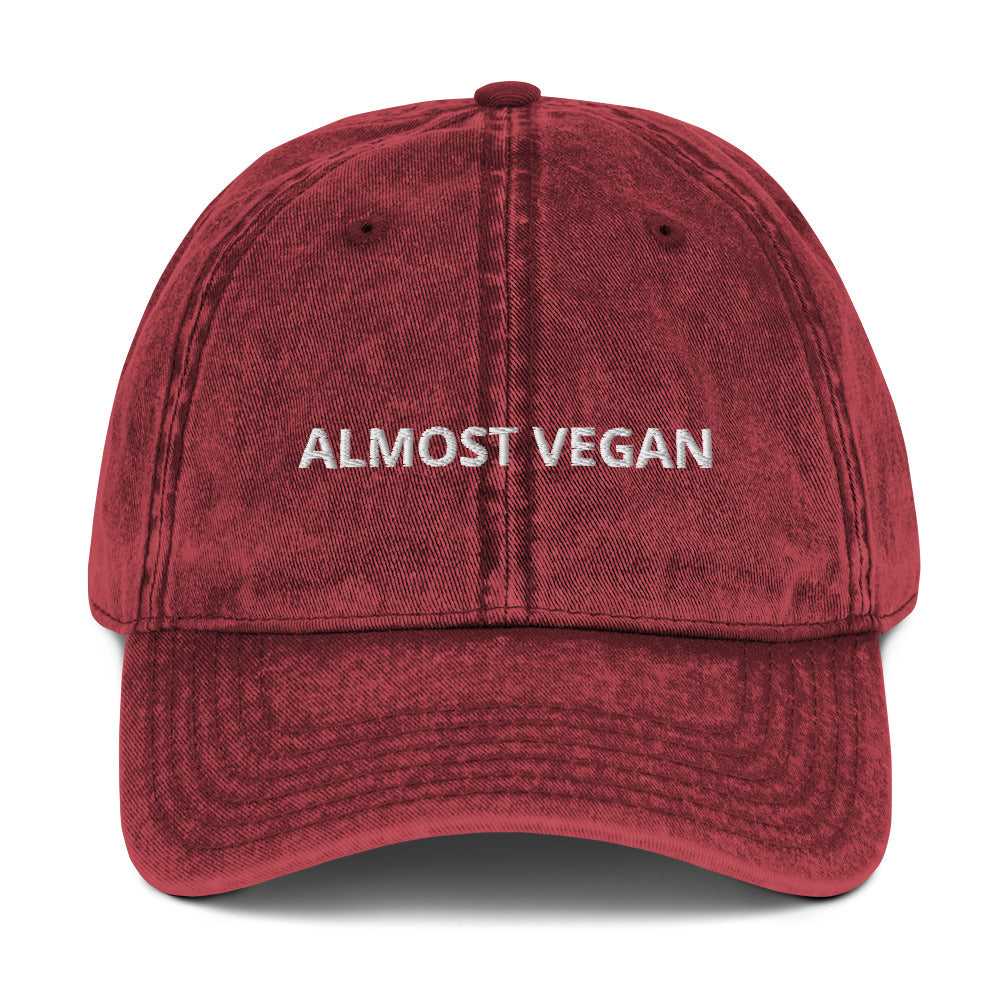 Produktbild der 'ALMOST VEGAN' bestickten Vintage-Cap auf weißem Hintergrund. Eine humorvolle und aufmerksamkeitsstarke Kopfbedeckung für Fleischliebhaber.